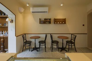 A restaurant interior with multiple dining tables and chairs, creating an inviting atmosphere for socializing and meals