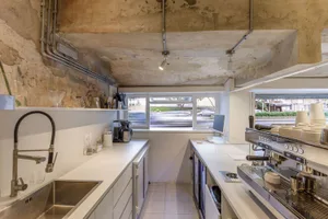 Modern kitchen and dining area with white cabinets, appliances, and a dining table surrounded by chairs, showcasing a clean and organized design