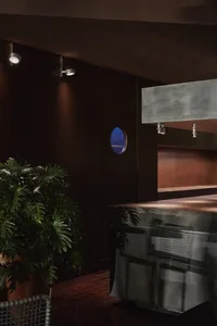 A modern kitchen with a wooden island and marble countertop, featuring two chairs and a warm atmosphere