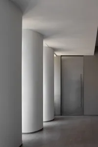 Empty industrial hallway with concrete walls and white pillars, creating a sense of simplicity and modernity