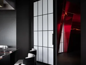 Dining room with a black wall, red accents, a dining table, two chairs, and a book on the table