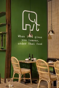 Cozy dining area with a table, chairs, green walls, and various items on the table