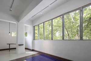 A bright and spacious interior space with white walls and large windows that allow natural light to enter