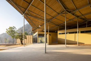 Open public space with a large wooden structure, metal accents, and natural light from windows