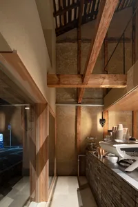 Casual restaurant interior with a counter, dining table, and scattered bowls, featuring a sink in the background