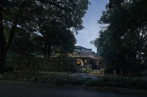 A traditional house with a stone exterior surrounded by trees, providing a sense of tranquility and natural beauty