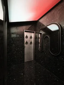 Black marble bathroom with a red accent wall, modern design, and sleek contemporary feel