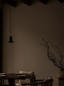 A cozy living room with a wooden dining table surrounded by chairs, creating a warm and inviting atmosphere