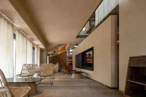 Warm and inviting living area with a large fireplace, wooden floors and walls, and potted plants