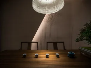 A warm and inviting dining area with a wooden table, four chairs, and a tea setting