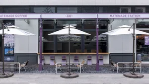 A restaurant dining area with tables, chairs, umbrellas, and potted plants, creating a warm and inviting atmosphere