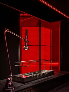 Modern kitchen with red walls, a metal sink with multiple faucets, and sleek design elements