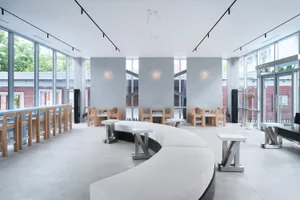 Open restaurant interior with modern design, multiple tables, benches, and warm ambient lighting