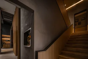 Cozy living area with a traditional staircase featuring dark wood steps and a mounted television