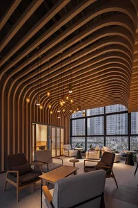 Warm and inviting open concept living area with a large wooden beam, multiple chairs, a dining table, and a potted plant