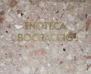 A modern hotel lobby with a marble wall and gold sign, featuring a sophisticated and welcoming atmosphere