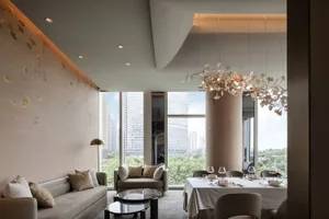 Elegant living space with a city view, two couches, a dining table, and decorative elements