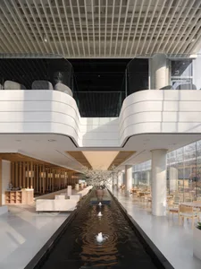 A large open lobby with a central waterfall, chairs, and a relaxing atmosphere