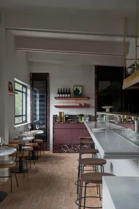elegant restaurant interior with a large marble bar, chairs, and wine glasses
