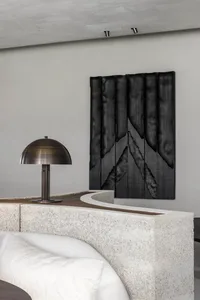 A well-lit modern living room with a white couch in front of a black curtain, two lamps on either side, and a comfortable atmosphere