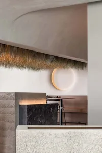 Dining space with a stone countertop, a thatch ceiling, and two dining tables, a chair, and a vase