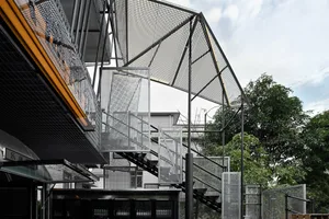 A modern building with multiple levels, metal structure, and stairs, showcasing a blend of architectural styles and materials