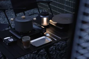 Outdoor dining area with a wooden table featuring cups, spoons, and a bowl, set in a relaxed and casual atmosphere