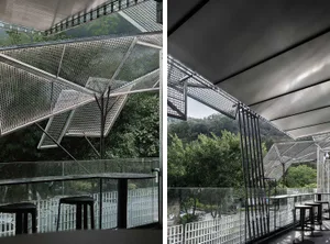 A patio area with a dining table and chairs surrounded by trees and a forest, with cars parked outside, blending nature and city life