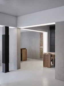 Empty room with white walls and floors, featuring two tables and three chairs in a clean and minimalistic space