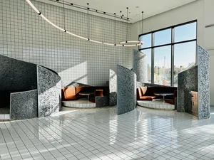 A modern living space with three couches, four chairs, and a dining table, creating a cozy and inviting atmosphere