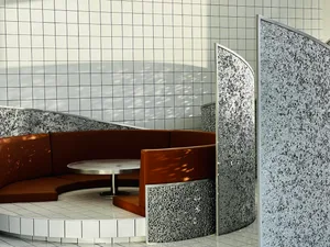A modern cafe seating area with multiple chairs and tables, featuring a clean and contemporary design with white and grey tones