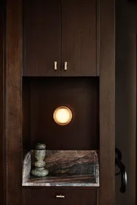 A wooden kitchen cabinet with a light on inside, creating a warm atmosphere