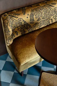 A cozy living space with a leather sofa and a wooden dining table, set against a neutral background