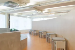 A bright and inviting space with multiple wooden tables and metal chairs, ideal for social gatherings or events