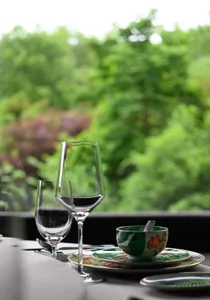 A well-arranged dining table with wine glasses and a bowl, set in a cozy room with inviting atmosphere