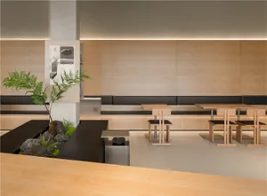 Empty restaurant with wooden walls and floors, featuring dining tables, chairs, and benches in a clean and inviting atmosphere