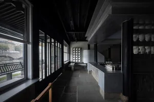 Modern bar area with a countertop, multiple bottles, and benches, giving a stylish and welcoming atmosphere