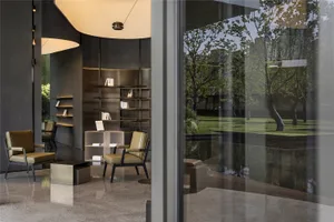 Cozy living space with a large bookshelf, two chairs, and a dining table, creating a warm and inviting atmosphere