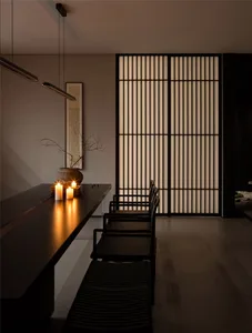A dining area with a black table and chairs, candles, and vertical blinds, conveying elegance and sophistication