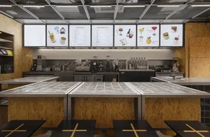 Industrial kitchen with multiple tables, chairs, and appliances, featuring functional and organized spaces for food preparation and serving