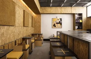 Warm and inviting cafe with wooden walls, tables, and chairs, designed for a large number of guests