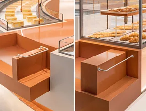 A kitchen with two countertops, one orange and one brown, featuring step-like designs and donuts and bottles on display