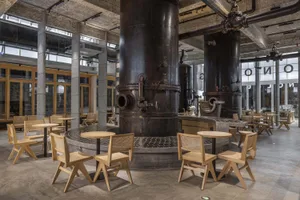 Industrial cafe with metal tanks, chairs, and dining tables in a modern and functional space