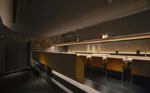 Modern kitchen with wooden cabinets and countertops, featuring a dining area with chairs and a warm atmosphere
