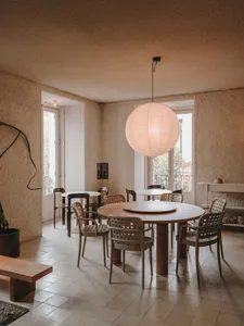 A warm and inviting dining space with a large round table surrounded by chairs, perfect for socializing and sharing meals