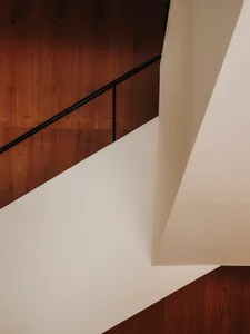 A well-lit staircase with wooden steps, set in a simple and functional space