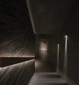 A darkened room with a stone staircase featuring two sets of steps, one on each side of the room