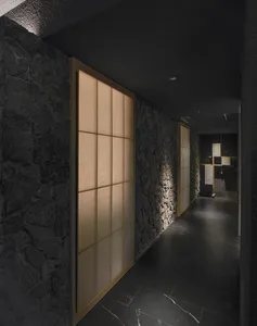 Dark hallway with stone walls, wooden door frames, and multiple doorways creating a sense of depth