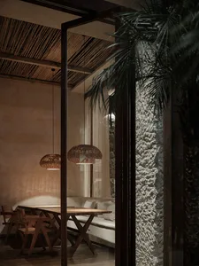 Modern living space with a wooden dining table, stone walls, and a warm inviting atmosphere
