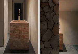 Dimly lit dining space with stone and marble surfaces, decorative elements, and a mix of natural and man-made materials